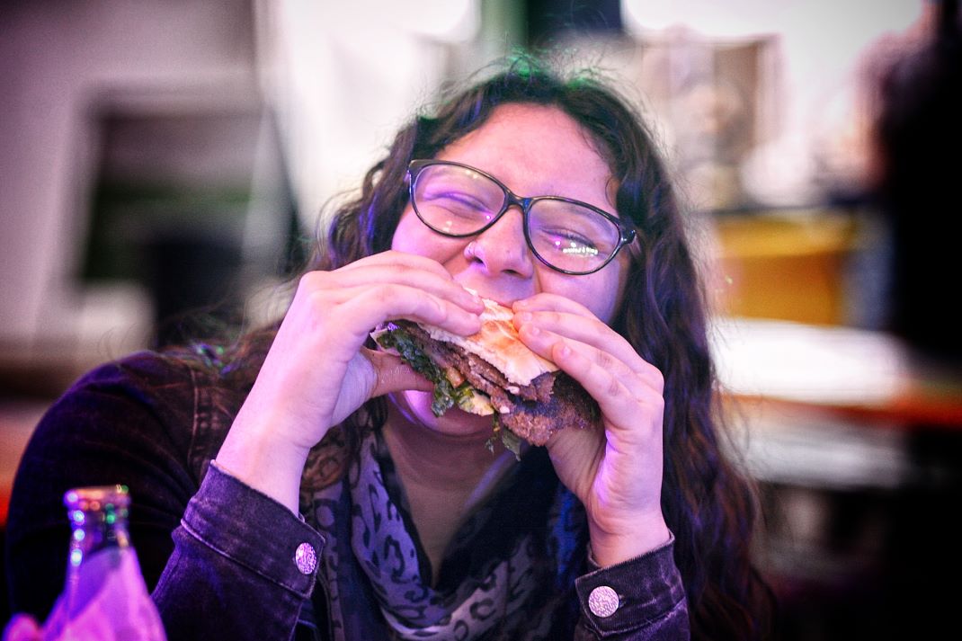 Eating a milanesa sandwich.